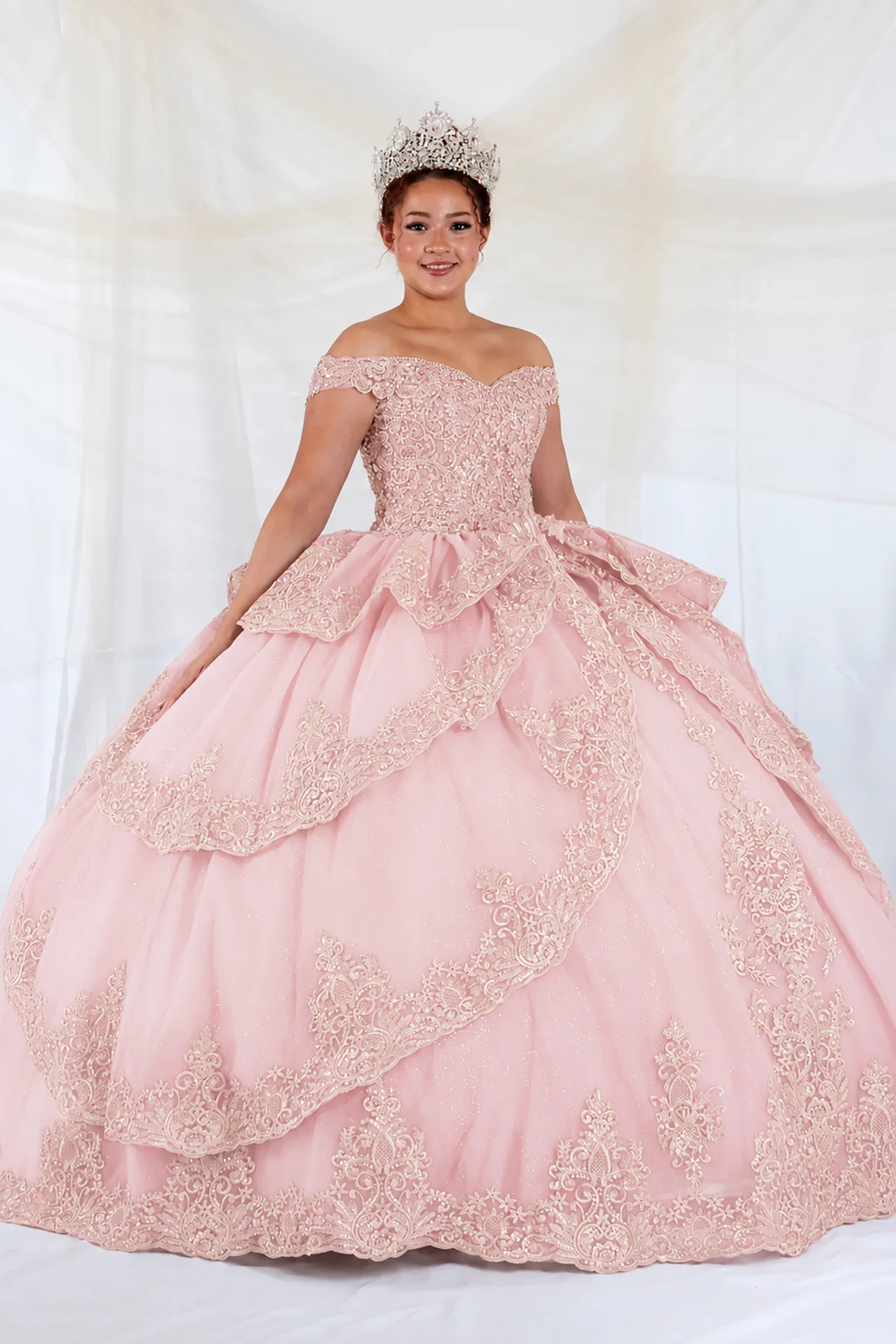 off-the-shoulder light pink quuinceanera ball gown with intricate lace applique and a tiered ruffled skirt