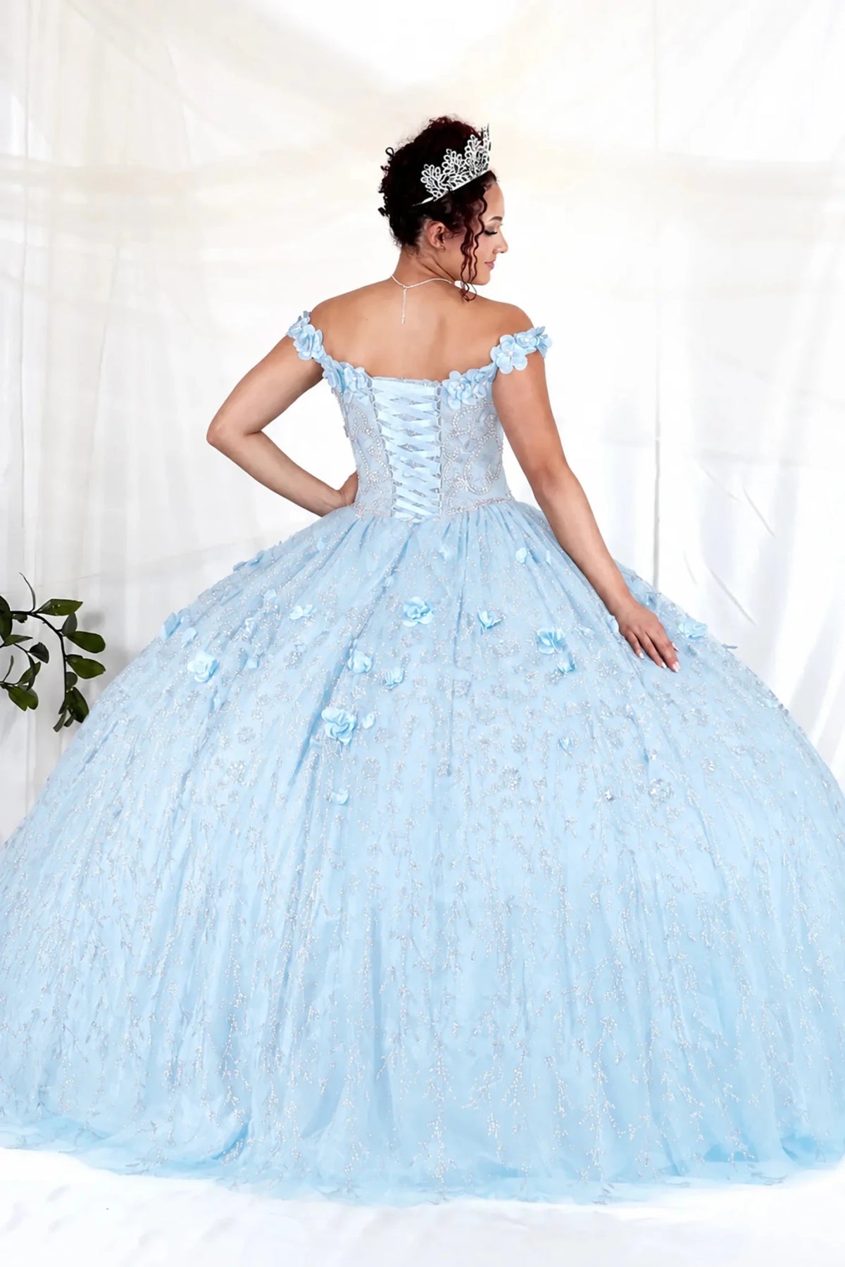 Bahama blue quinceañera ball gown with off‑shoulder neckline, delicate floral appliques and flowing skirt