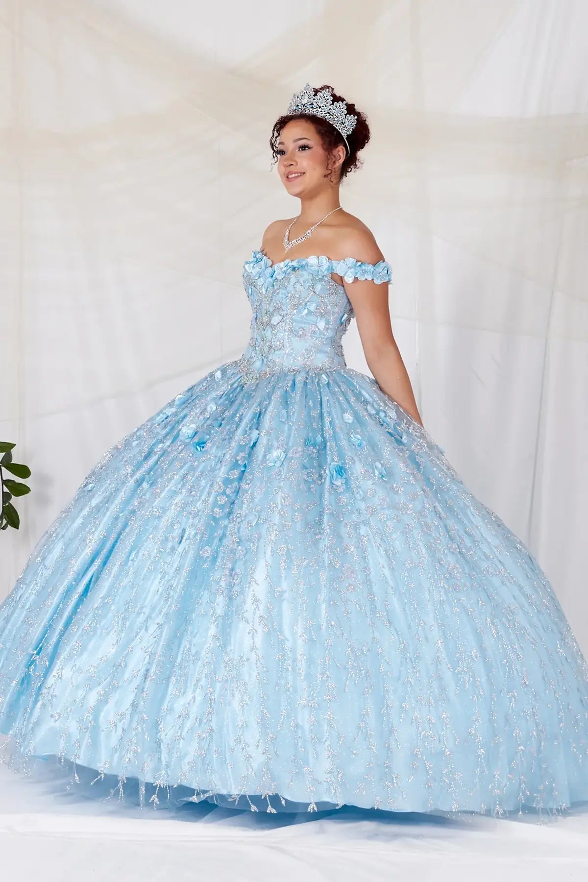 Bahama blue quinceañera ball gown with off‑shoulder neckline, delicate floral applique and flowing skirt