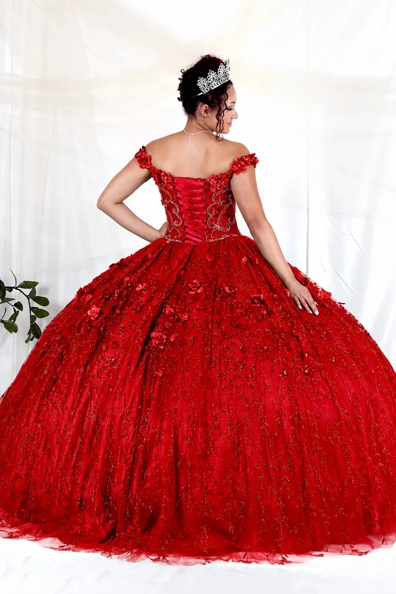Red quinceañera ball gown with off‑shoulder neckline, floral applique and flowing skirt