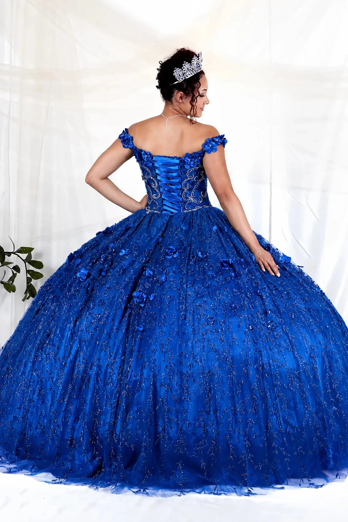 Royal blue quinceañera ball gown with off‑shoulder neckline, floral applique and flowing skirt