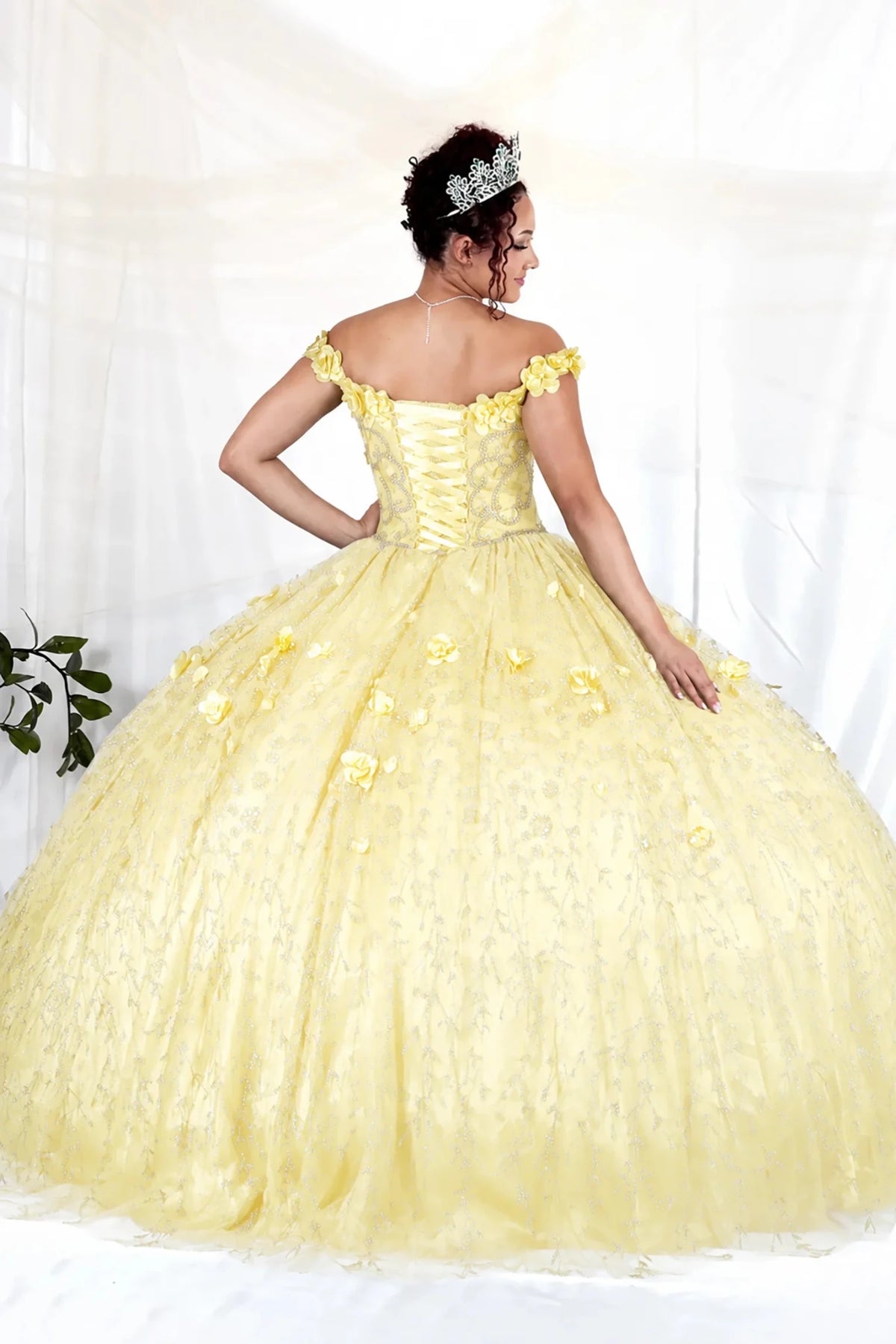 Yellow quinceañera ball gown with off‑shoulder neckline, floral applique and flowing skirt