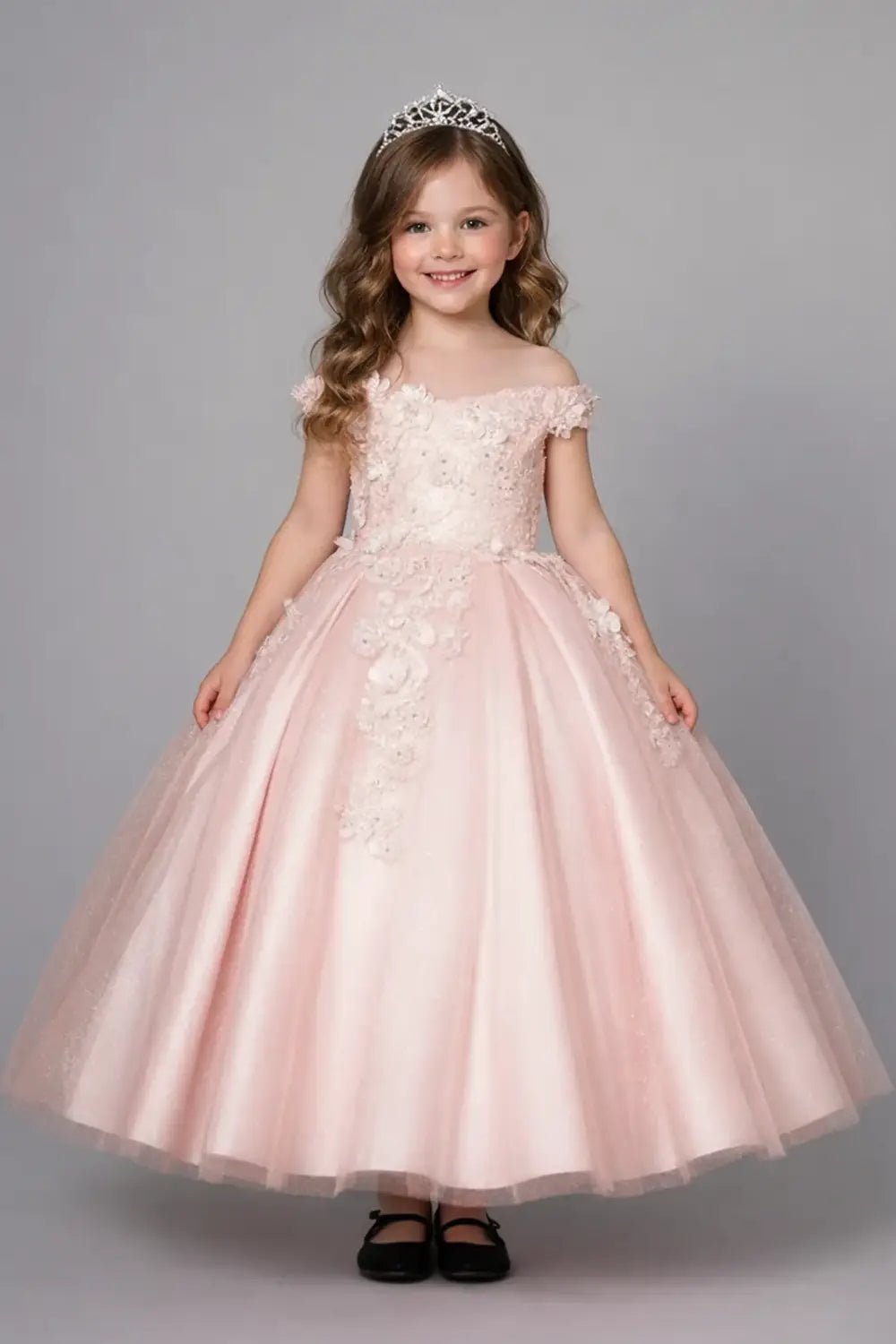 Kid standing front-facing in stunning blush ball gown with 3D floral appliqué bodice, glitter accents, and voluminous full skirt