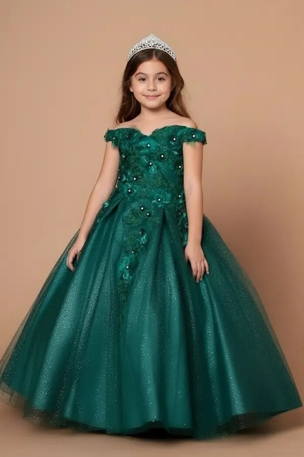 Kid standing front-facing in stunning emerald ball gown with 3D floral appliqué bodice, glitter accents, and flowing full skirt
