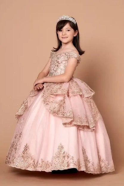 Kid standing side-facing in blush and gold ball gown with ornate embroidered layers, shimmering accents, and flowing full skirt