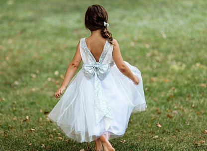 Silver / White USA Made | Sequin V-Back Tulle Flower Girl Dress with detachable Ribbon pin - back view of girl wearing dress with bow